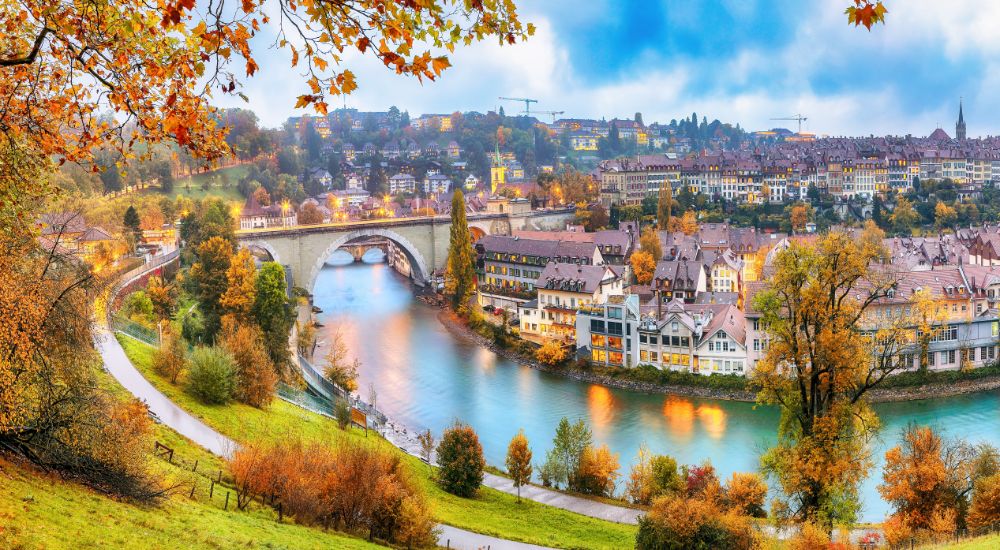 Discover and Roam - Bern City in Autumn on Aare River With Pont de Nydegg Bridge and Nydeggkirche - Protestant Church